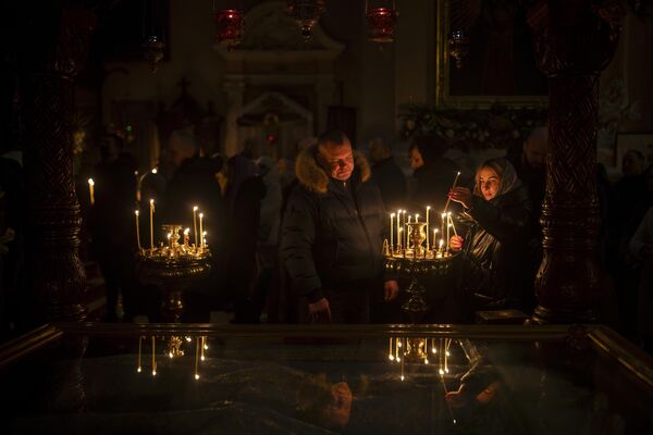 Lithuanian Orthodox Church worshippers light candles before the liturgy on Orthodox Christmas Eve in the Orthodox Church of the Holy Spirit in Vilnius, Lithuania. - Sputnik International