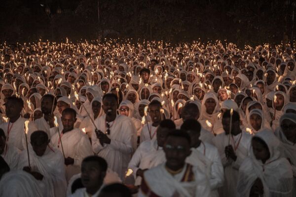 Ethiopian Orthodox worshippers hold candles as they gather to pray ahead of the Ethiopian Orthodox Christmas celebrations at the Bole Medhanialem Church in Addis Ababa, Ethiopia. - Sputnik International