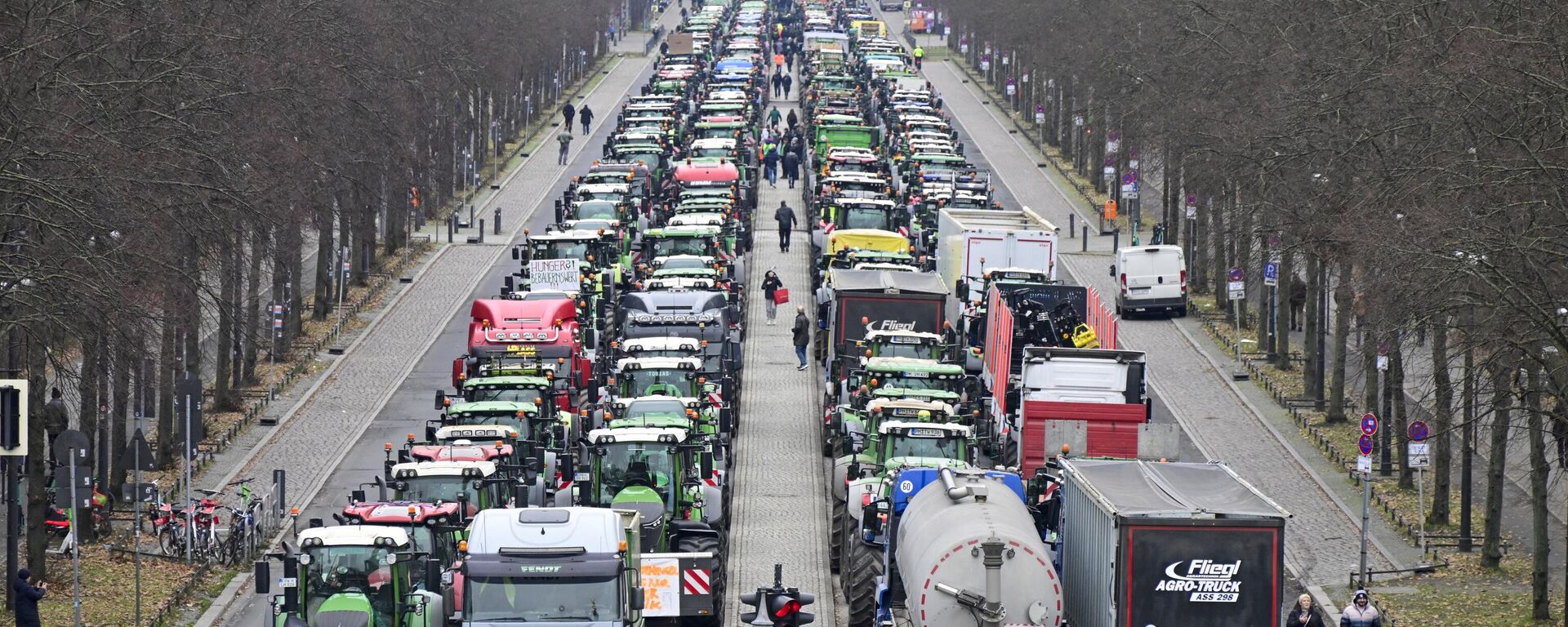 Tractors are lined up in the Strasse des 17 Juni boulevard, towards the Brandenburg Gate in Berlin, on December 18, 2023, as German farmers demonstrate against the planned abolition of subsidies for agricultural diesel. - Sputnik International, 1920, 05.02.2024