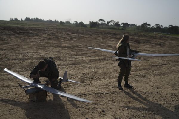 IDF troops take stock of a pair of turboprop recon drones in an open field. - Sputnik International