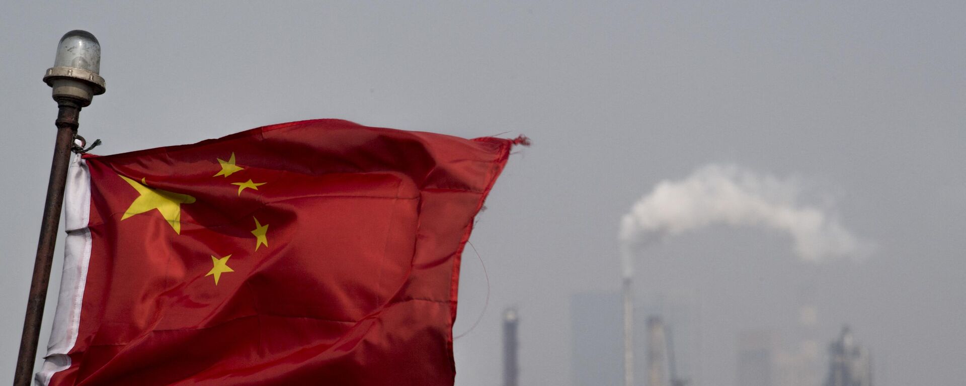This picture taken on March 22, 2018 shows a Chinese flag fluttering in front of the Shanghai Gaoqiao Company Refinery in Shanghai.  - Sputnik International, 1920, 11.01.2024
