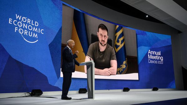  Founder and executive chairman of the World Economic Forum Klaus Schwab welcomes Ukrainian President Volodymyr Zelensky seen on a giant screen by video link at the Congress centre during the World Economic Forum (WEF) annual meeting in Davos on May 23, 2022. Zelensky is similarly expected to attend the WEF's 2024 meetings this week. - Sputnik International