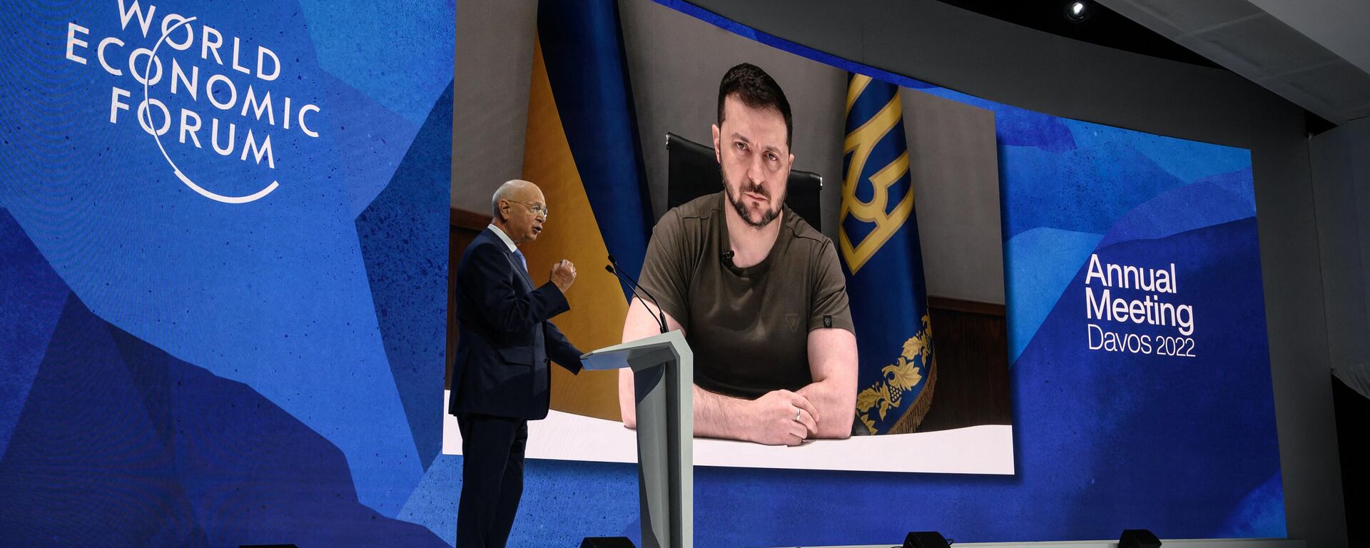  Founder and executive chairman of the World Economic Forum Klaus Schwab welcomes Ukrainian President Volodymyr Zelensky seen on a giant screen by video link at the Congress centre during the World Economic Forum (WEF) annual meeting in Davos on May 23, 2022. Zelensky is similarly expected to attend the WEF's 2024 meetings this week. - Sputnik International, 1920, 15.01.2024