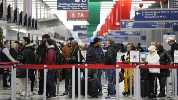 Travelers wait to go through security check point at the O'Hare International Airport in Chicago, Sunday, Jan. 14, 2024. Over 70 flight cancellations at Chicago airports Sunday. (AP Photo/Nam Y. Huh) - Sputnik International