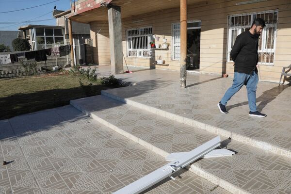 A man inspects the damage at a home following a missile strike. - Sputnik International
