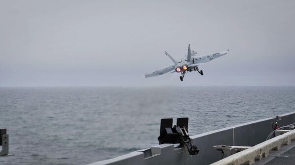In this Wednesday, April 15, 2015 image released by U.S. Navy Media Content Services, an F/A-18E Super Hornet, assigned to the Knighthawks of Strike Fighter Attack Squadron 136, launches off the flight deck aboard Nimitz-class aircraft carrier USS Theodore Roosevelt in the Fifth Fleet area of operations - Sputnik International