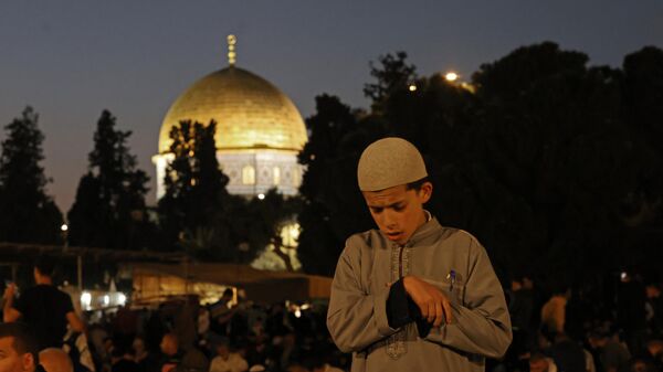 A Muslim youth prays on Laylat al-Qadr, one of the holiest nights during the holy fasting month of Ramadan, outside the Dome of the Rock in Jerusalem's Al-Aqsa Mosque compound on April 17, 2023. - Sputnik International