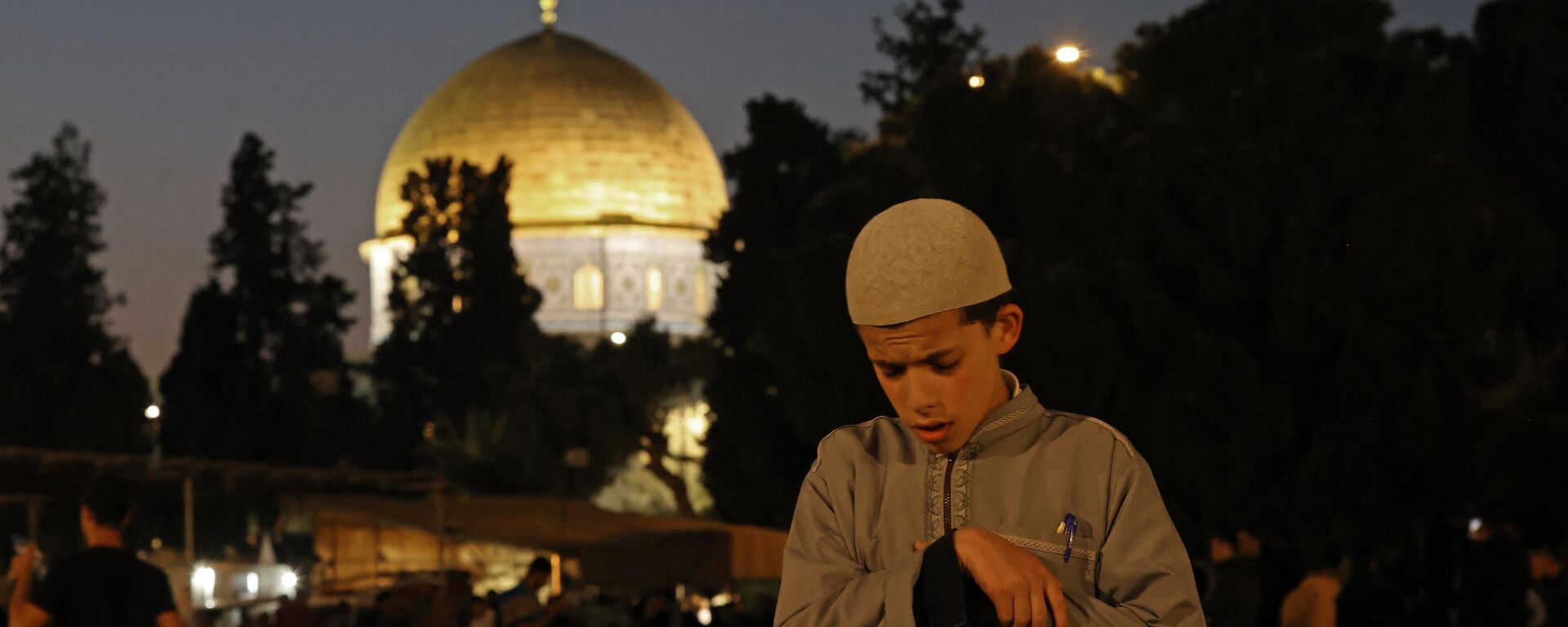 A Muslim youth prays on Laylat al-Qadr, one of the holiest nights during the holy fasting month of Ramadan, outside the Dome of the Rock in Jerusalem's Al-Aqsa Mosque compound on April 17, 2023. - Sputnik International, 1920, 18.01.2024