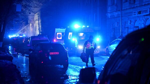 A law enforcement officer walks past ambulances parked at the site of a missile attack in Kharkov late on January 16 - Sputnik International