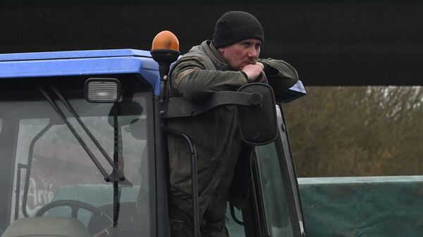A French farmer stands on his tractor as farmers block a highway, near Beauvais, northern France. Farmers have for months been protesting for better pay and against what they consider to be excessive regulation, mounting costs and other problems.  - Sputnik International