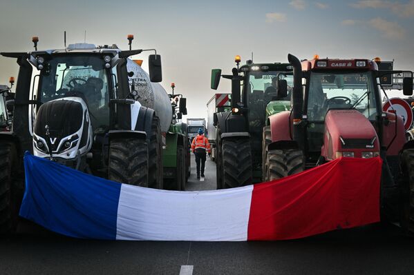 This photograph shows the French national flag draped between two tractors as farmers block the A7 motorway near Albon, southeastern France. - Sputnik International