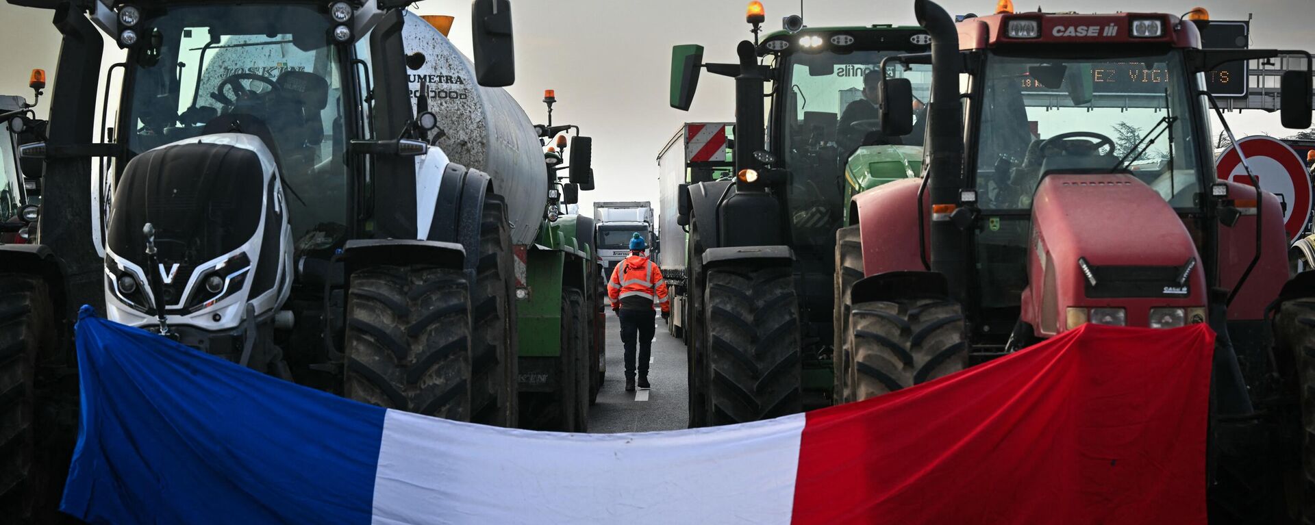 This photograph shows the French national flag drapped between two tractors as farmers block the A7 motorway near Albon, southeastern France.  - Sputnik International, 1920, 29.01.2024