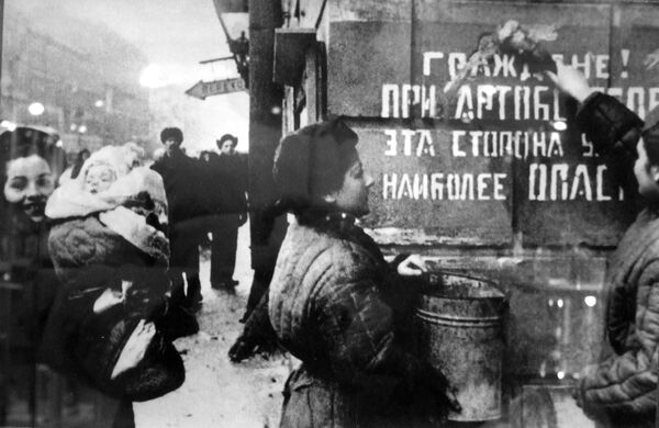 Leningrad cheers. The siege is lifted. A sign on the wall reads: &quot;Citizens! This part of the street is most dangerous during the artillery barrage.&quot; - Sputnik International