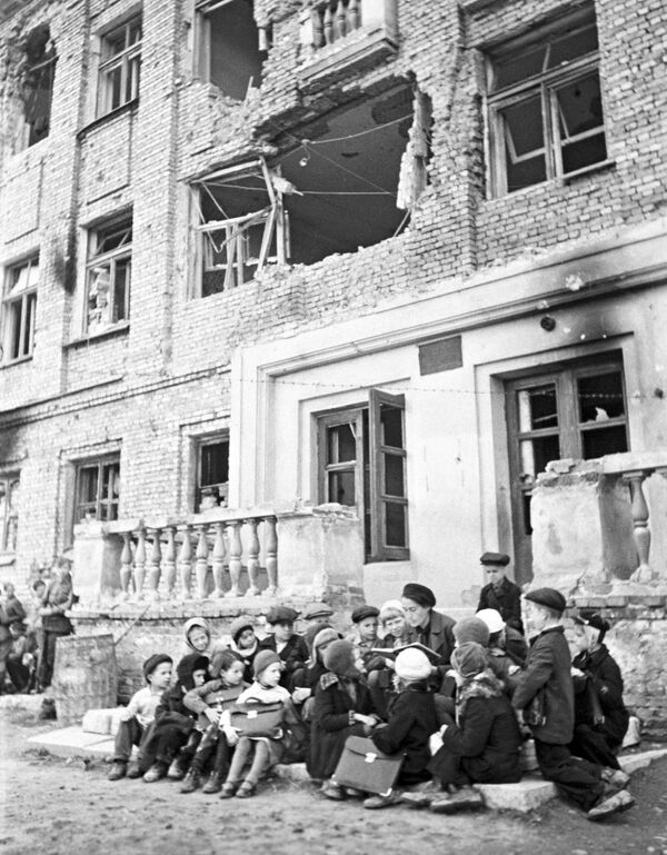 A lesson on the doorstep of the school destroyed by German shelling during the Siege of Leningrad. - Sputnik International