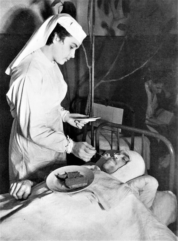 Anna Yushkevich, a nurse at the Leningrad Naval Hospital, feeds a wounded Red Navy sailor from the &quot;V.A. Ukhov&quot; patrol ship. - Sputnik International