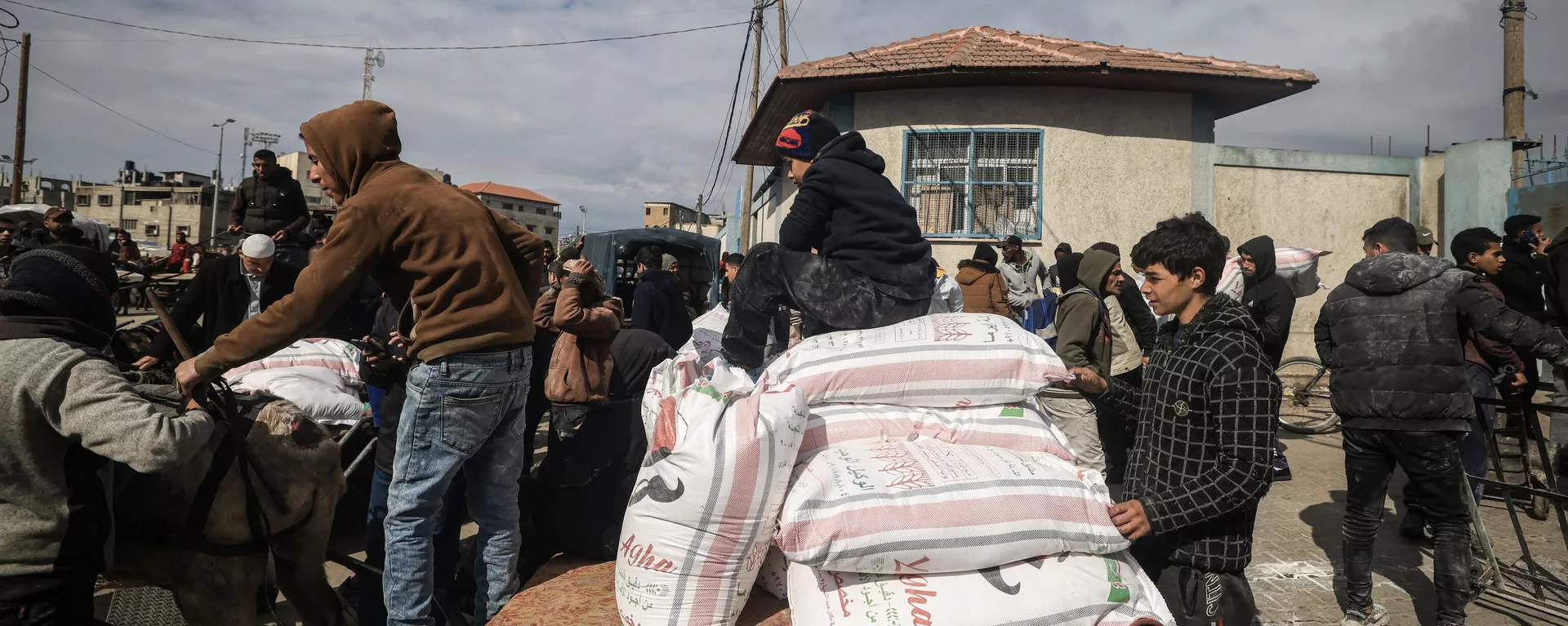 Displaced Palestinians receive food aid at the United Nations Relief and Works Agency for Palestine Refugees (UNRWA) center in Rafah in the southern Gaza Strip on January 28, 2024, amid ongoing battles between Israel and the Palestinian militant group Hamas - Sputnik International, 1920, 27.07.2024