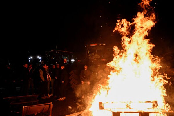 French farmers are seen gathering around a bonfire as they set up a new blockade on the A6 highway near Chilly-Mazarin, south of Paris. This is being done to enable them to get closer to the Rungis wholesale food market, as part of their ongoing protest. - Sputnik International