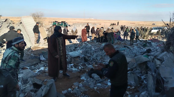  Residents gather around destroyed buildings after US warplanes carried out an airstrike on the headquarters of Hashd al-Shaabi (Popular Mobilization Forces) in Al-Qaim city of Anbar, Iraq on February 3, 2024. - Sputnik International