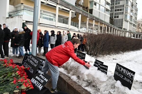 Young Guard of United Russia and Volunteer Company activists lay flowers at a makeshift memorial in Moscow mourning the victims of the Ukrainian shelling in Lisichansk. - Sputnik International