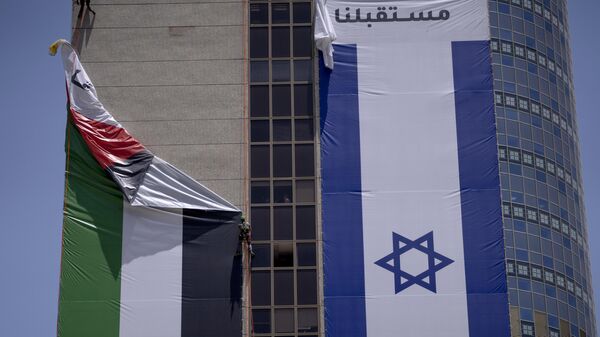 A Palestinian flag is removed from a building by Israeli authorities after being put up by an advocacy group that promotes coexistence between Palestinians and Israelis, in Ramat Gan, Israel, Wednesday, June 1, 2022 - Sputnik International