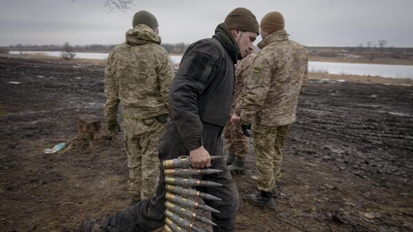 A Ukrainian serviceman carries large caliber ammunitions for armored fighting vehicles mounted weapons in the Donetsk region, Thursday, Feb. 10, 2022 - Sputnik International