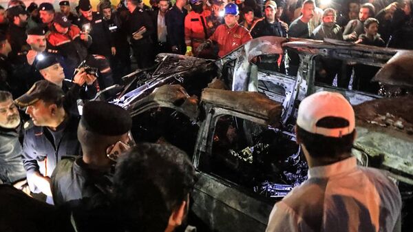 People, rescuers and security forces gather around a vehicle hit by a drone strike, reportedly killing three people, including two leaders of the Kataib Hezbollah militant group, in Baghdad on February 7, 2024 - Sputnik International
