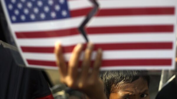 A Muslim youth holds up a defaced U.S. flag during an anti-Israel protest marking the International Al-Quds Day outside the U.S. Embassy in Jakarta, Indonesia, Friday, Aug. 2, 2013 - Sputnik International