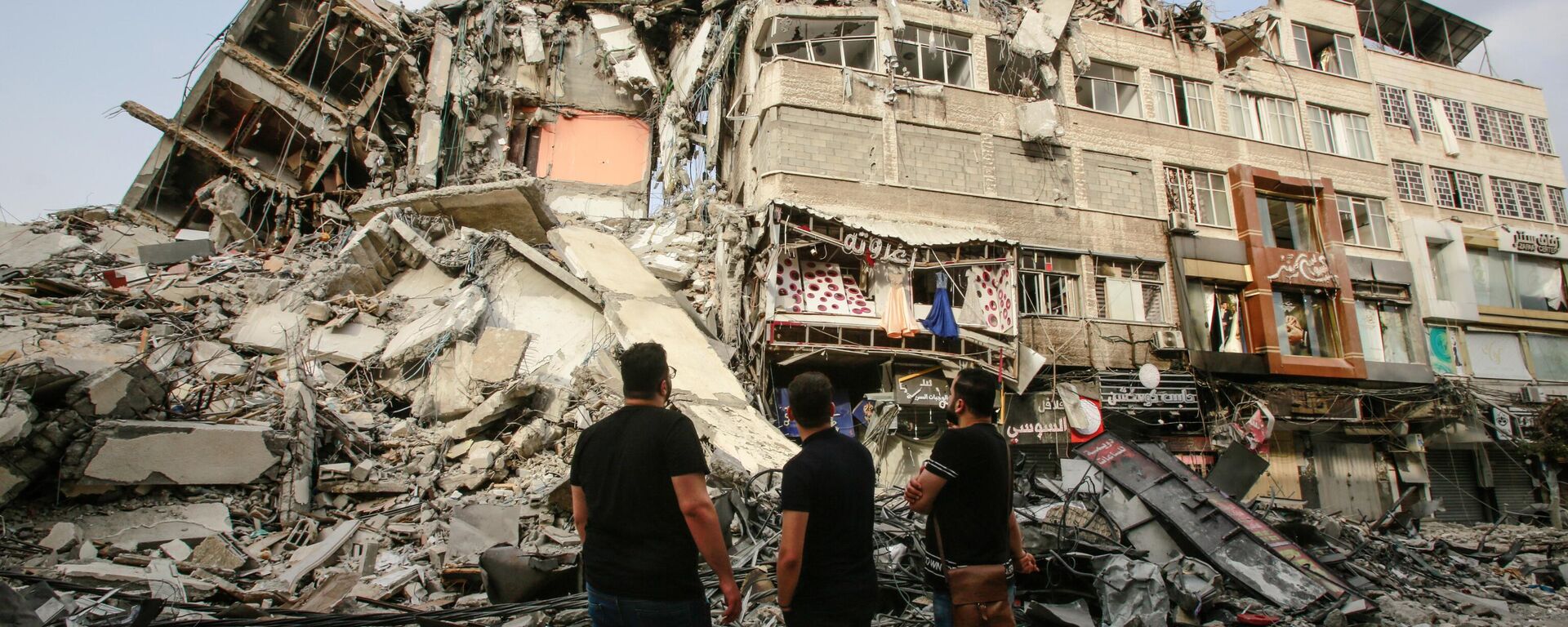 Palestinians look at ruins of a residential building - Sputnik International, 1920, 09.02.2024