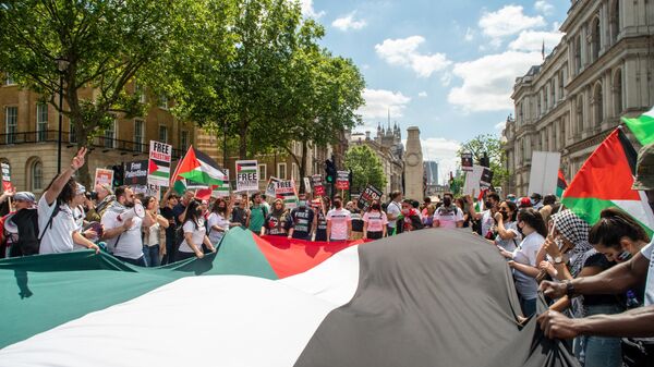 People hold a giant flag during the Justice For Palestine rally - Sputnik International