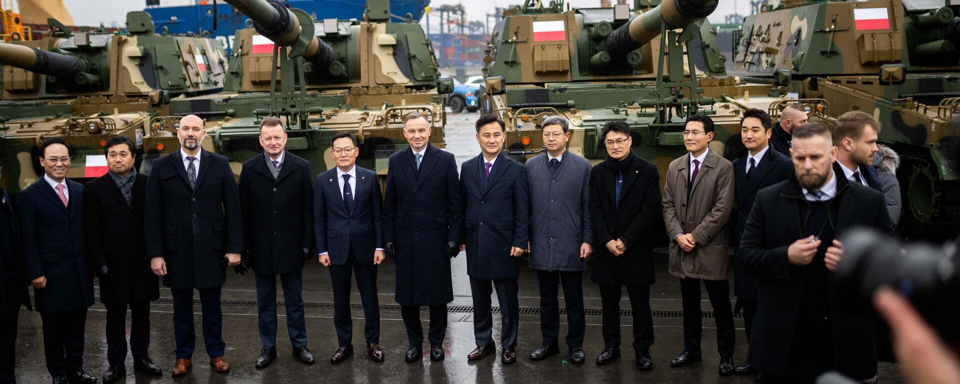 Polish President Andrzej Duda (6L), Minister of South Korea's state arms procurement agency Eom Donghwan (7L) and Polish Defence Minister Mariusz Blaszczak (4L) pose with officials during the acceptance of the first South Korean K2 battle tanks and South Korean K9 howitzers for Poland in December 6, 2022 at the Baltic Container Terminal in Gdynia.  - Sputnik International, 1920, 10.02.2024