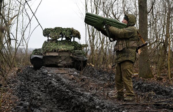 Russian Armed Forces serviceman with an anti-drone gun near a T-62 tank. - Sputnik International