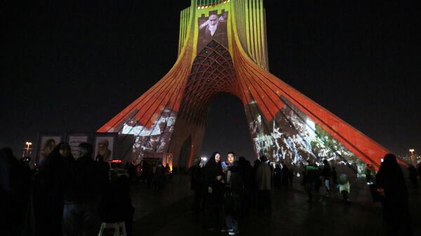 The famous Azadi (Freedom) Tower is illuminated with historical photographs of the late Iranian Supreme Leader Ayatollah Ruhollah Khomeini, leader of the Islamic Revolution, and Iran's national flag during a ceremony of the 45th anniversary of the Islamic Revolution, in Tehran, February 10, 2024. - Sputnik International