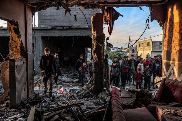 People inspect debris and rubble in a building heavily damaged by the Israeli bombardment.  - Sputnik International