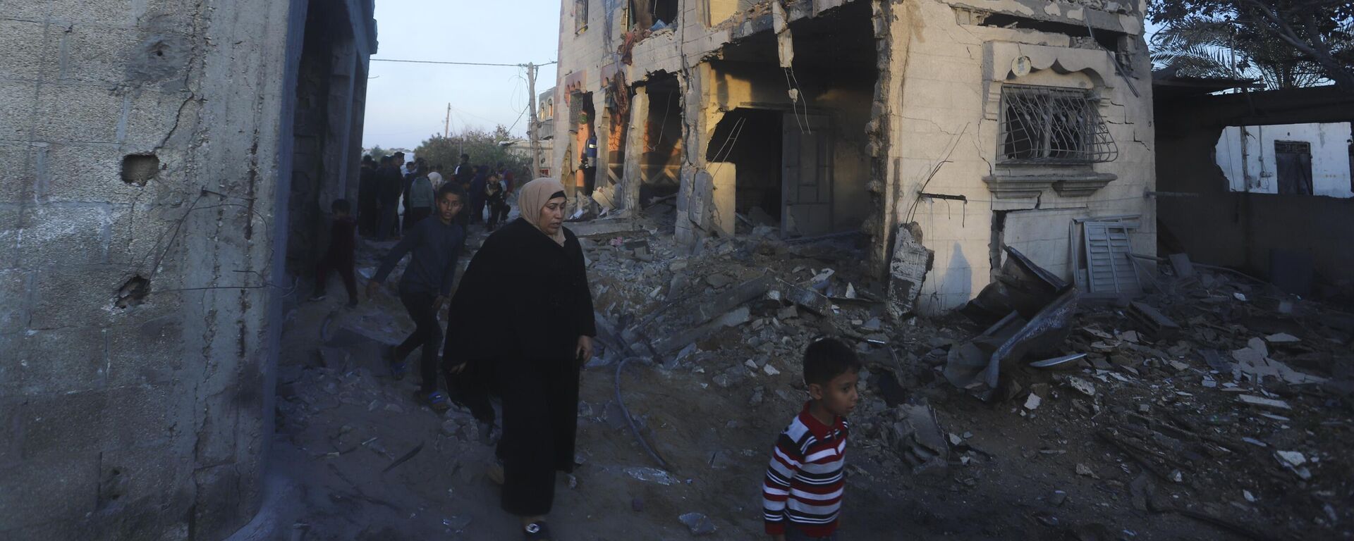 Palestinians walk by a residential building destroyed in an Israeli strike in Rafah, Gaza Strip, Sunday, Feb. 11, 2024 - Sputnik International, 1920, 08.03.2024