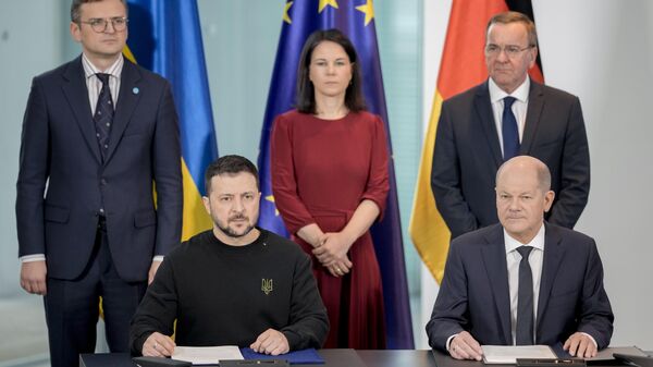 German Chancellor Olaf Scholz and Ukrainian President Volodymyr Zelensky sign a treaty in the chancellory in Berlin - Sputnik International