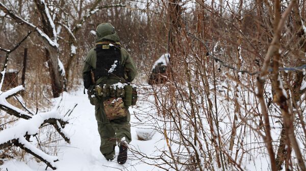 Russian soldier walks through a wooded area in the Avdeyevka direction. February 14, 2024. - Sputnik International