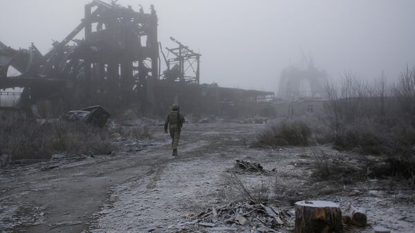A Ukrainian soldier passes by a destroyed Butovka coal mine as he approaches his front line position in the town of Avdeyevka in the Donetsk region - Sputnik International