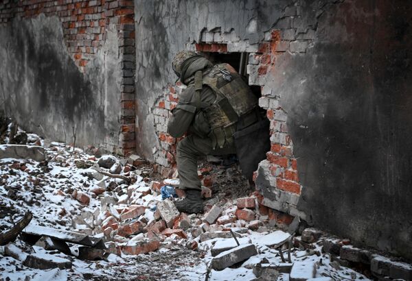 A Russian fighter inspects the rubble of a destroyed building in liberated Avdeyevka. - Sputnik International
