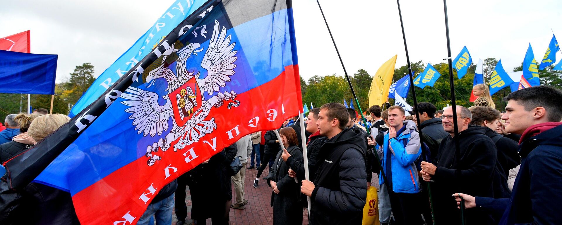 People wave flags during a concert on the day of new regions' reunification with Russia - Sputnik International, 1920, 12.12.2025