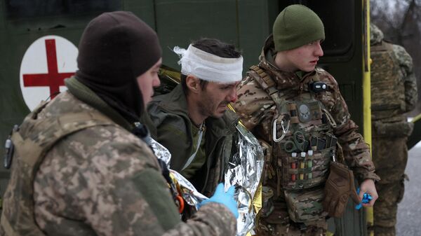 Medics of Ukrainian Army evacuate a wounded soldier on a road not far of Soledar, Donetsk region on January 14, 2023ю - Sputnik International