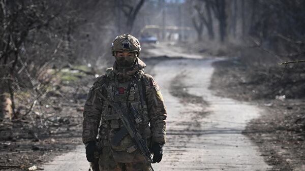 A Russian serviceman of the 55th motorised rifle brigade of the Central Military District patrols an area in Avdeyevka - Sputnik International