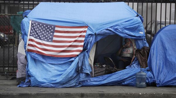 A man smokes inside a tent on skid row Friday, March 20, 2020, in Los Angeles. Auditors said Tuesday, Aug. 24, 2021 - Sputnik International