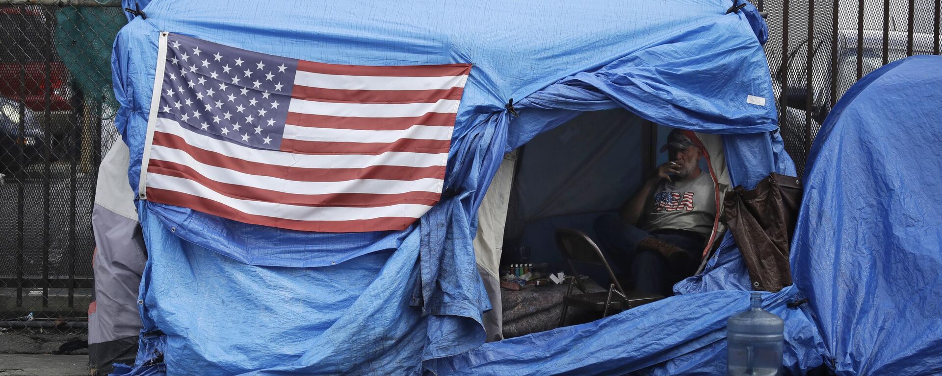 A man smokes inside a tent on skid row Friday, March 20, 2020, in Los Angeles. Auditors said Tuesday, Aug. 24, 2021 - Sputnik International, 1920, 26.02.2024