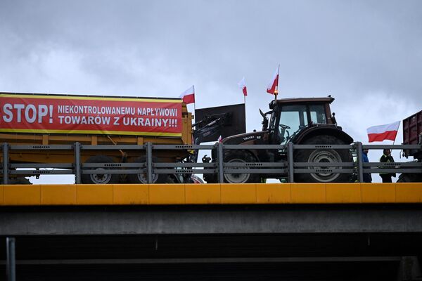 A banner reading “Stop to uncontrolled supply of goods from Ukraine” placed on a tractor with Polish flags outside the town of Ryki (Lublin region), Poland. - Sputnik International