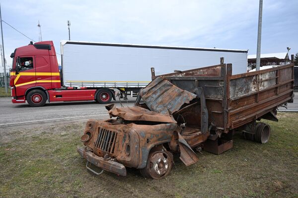 A truck drives by a damaged Ukrainian agricultural vehicle that was brought to the Ukraine-Poland border by Ukrainian farmers at the Krakovets border crossing, Poland. - Sputnik International