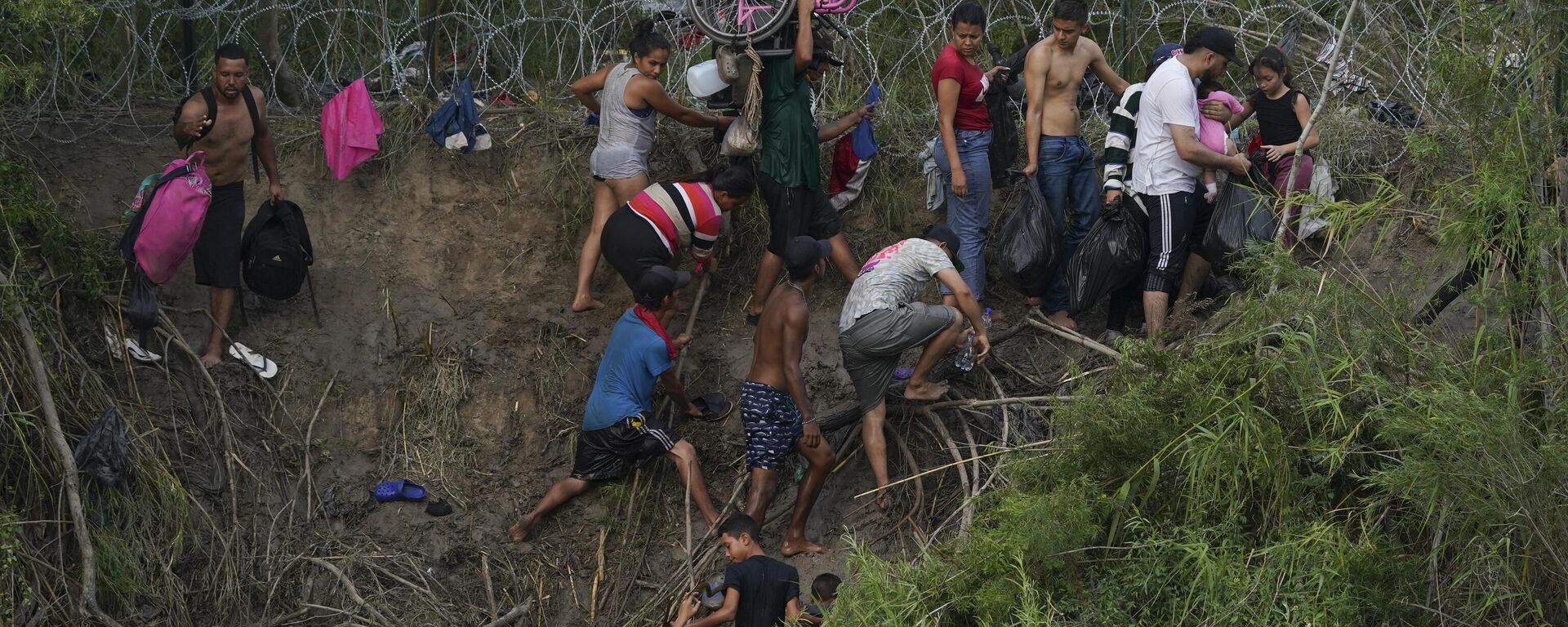 Migrants walk up the bank on the U.S. side of the Rio Grande river, as seen from Matamoros, Mexico, Wednesday, May 10, 2023 - Sputnik International, 1920, 26.02.2024
