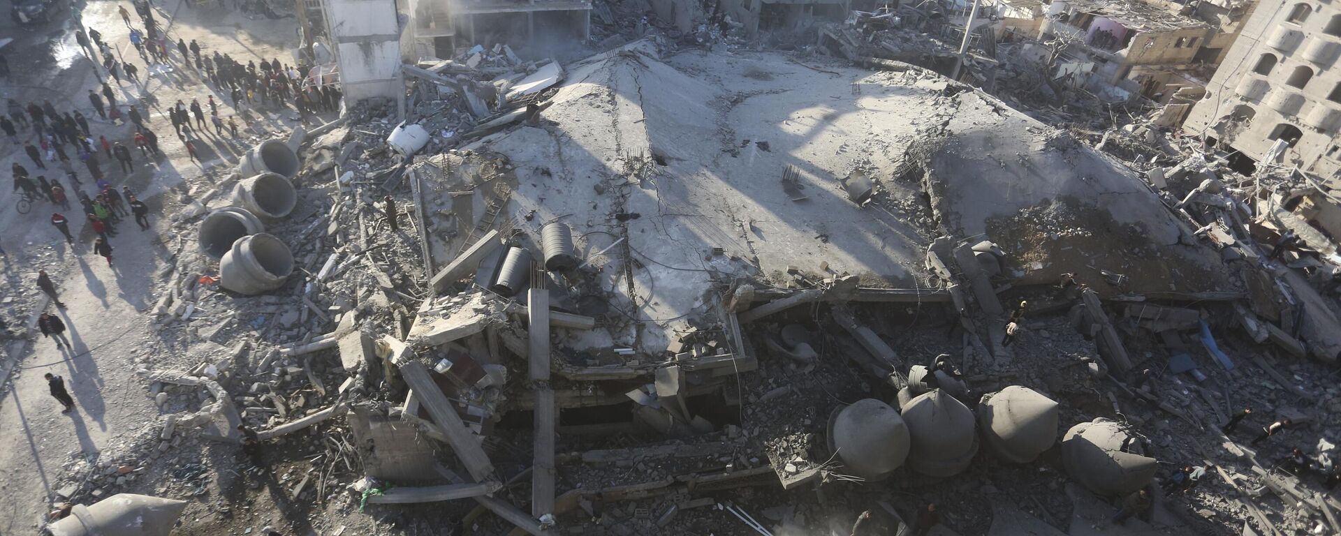 فلسطینی‌ها به تخریب پس از حمله اسرائیل به ساختمان‌های مسکونی و یک مسجد در رفح، نوار غزه، در روز پنجشنبه، فوریه، نگاه می‌کنند.  22، 2024 - Sputnik International، 1920، 2024/02/27
