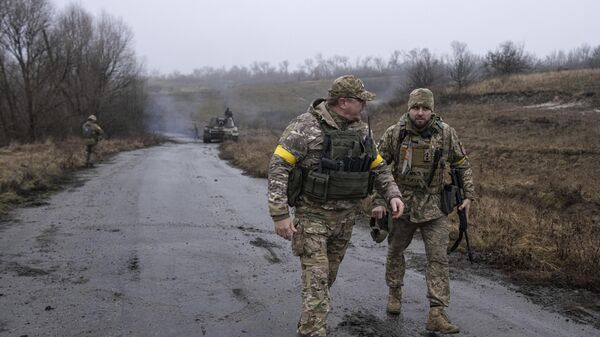 A Ukrainian brigade commander Dyadya Roma speaks to his comrade at a frontline in the Kharkov region, Ukraine, Saturday, Dec. 24, 2022 - Sputnik International
