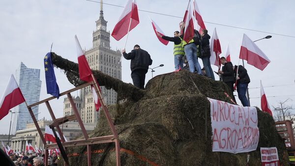 Polish farmers with national flags and angry slogans written on boards, protest against European Union green policies that trim their production and against cheap grain and other food imports from Ukraine, in Warsaw, Poland, on Tuesday, Feb. 27, 2024 - Sputnik International