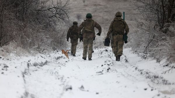 Ukrainian soldiers walk along the road on December 13, 2023, - Sputnik International